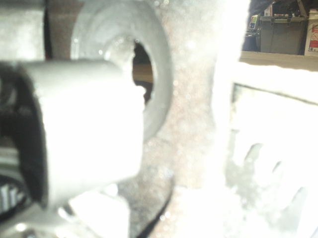Close-up of a metal part with a circular opening. Supermotors.net logo visible