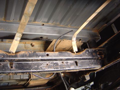 1986 Ford Bronco - Underside view of vehicle frame showing gas tank straps and fuel lines, part of the gas tank/sending unit system.