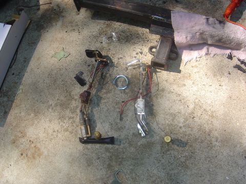 1986 Ford Bronco - Fuel pump and sending unit parts are disassembled and placed on a concrete surface.