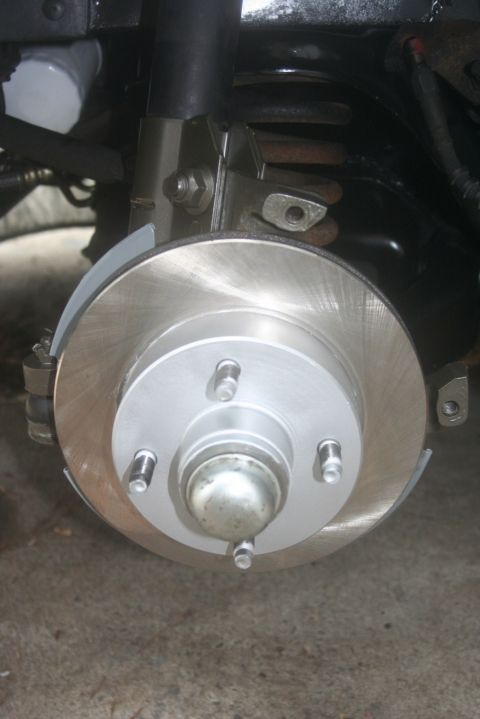 1980 Ford Mustang - Close-up of a car's brake system, showing a rotor, caliper, and suspension parts. Text from a watermark is visible.