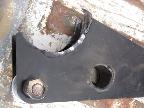 1995 Ford Bronco - A close-up view of a black metal suspension component, a large bolt and washer.