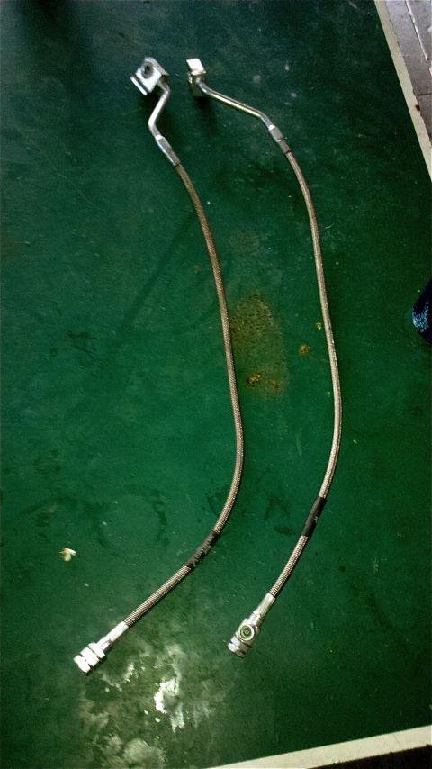 1995 Ford F-150 - Two braided metal brake lines are shown, likely for sale or repair.