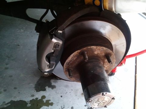 1994 Ford Bronco - This image shows a close-up view of a vehicle's brake system, including the rotor and caliper.