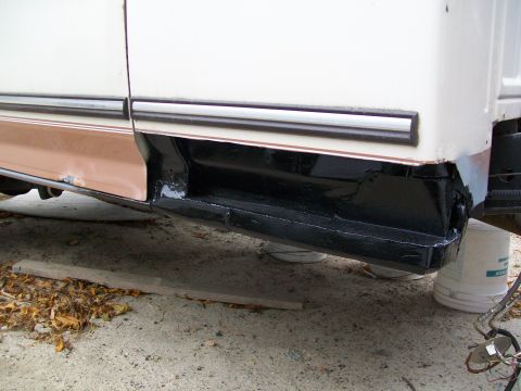 1995 Ford F-150 - The rocker panel of a truck is visible, undergoing repair and painting.