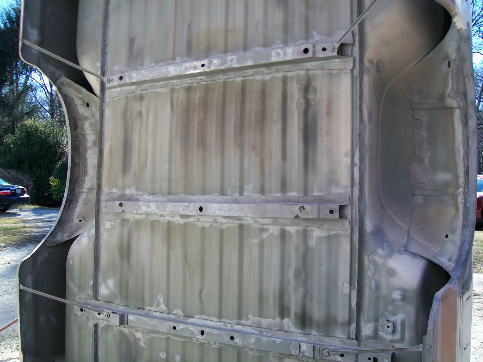 Underside of a truck bed, showing ribbed metal and frame mounts