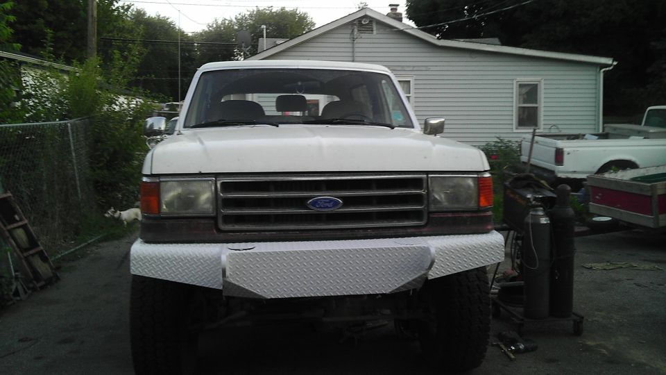 White Ford Bronco with custom diamond plate bumper, front view