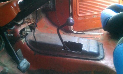 1969 Ford F-250 - Interior view of an orange truck, showing the floor shifter and seats, with a website watermark at the bottom.
