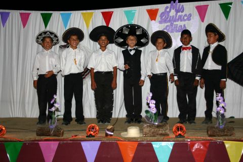1986 Ford Bronco - Children dressed in traditional Mexican outfits pose on a stage decorated for a celebration.