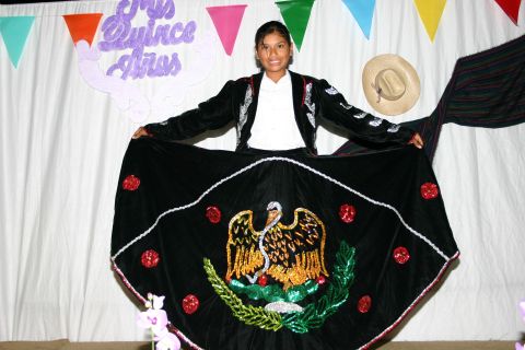 1986 Ford Bronco - A young woman poses in a traditional Mexican dress adorned with an eagle emblem, celebrating a Quinceañera.