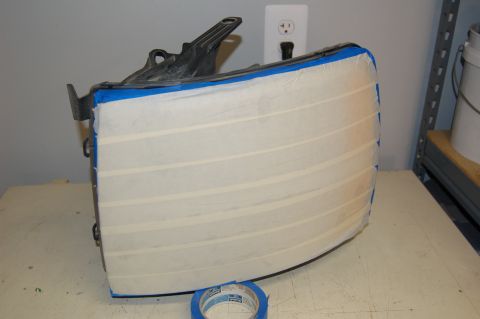 2007 Chevrolet Silverado 1500 - A headlight assembly is prepared for modification with masking tape.