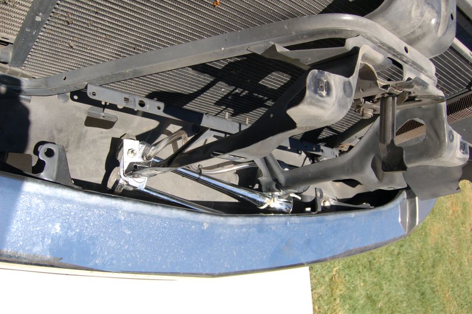 Front bumper and radiator support structure of a vehicle, showing mounting brackets and some chrome components
