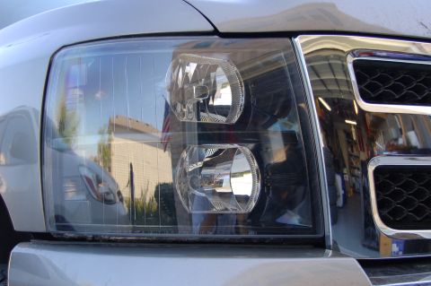2007 Chevrolet Silverado 1500 - Close-up view of the front headlight and chrome grille of a 2007 Chevrolet Silverado 1500.