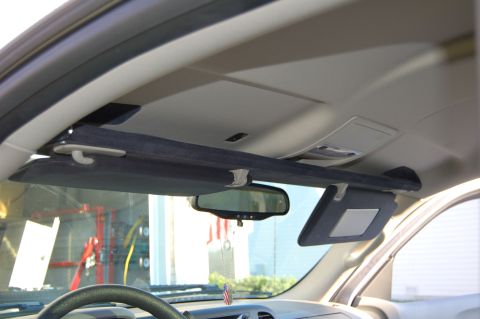 2007 Chevrolet Silverado 1500 - The interior of a vehicle shows the overhead console and sun visors, with a rearview mirror reflecting an American flag.
