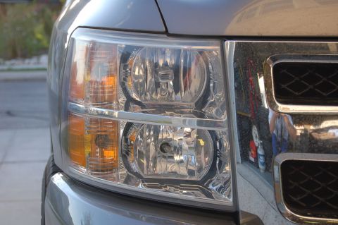2007 Chevrolet Silverado 1500 - Close-up of the front headlight and chrome grille of a gray truck, with a website watermark visible.