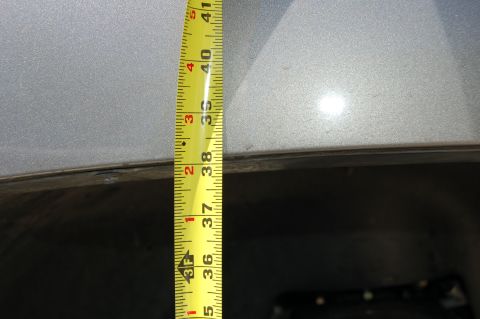 2007 Chevrolet Silverado 1500 - Measuring vehicle height with a tape measure against the body panel.