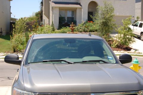 2007 Chevrolet Silverado 1500 - The front of a gray 2007 Chevrolet Silverado 1500 is visible, parked in front of a house.