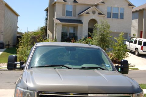 2007 Chevrolet Silverado 1500 - Front view of a silver 2007 Chevrolet Silverado 1500 pickup truck large tow mirrors and a white SUV in the background.