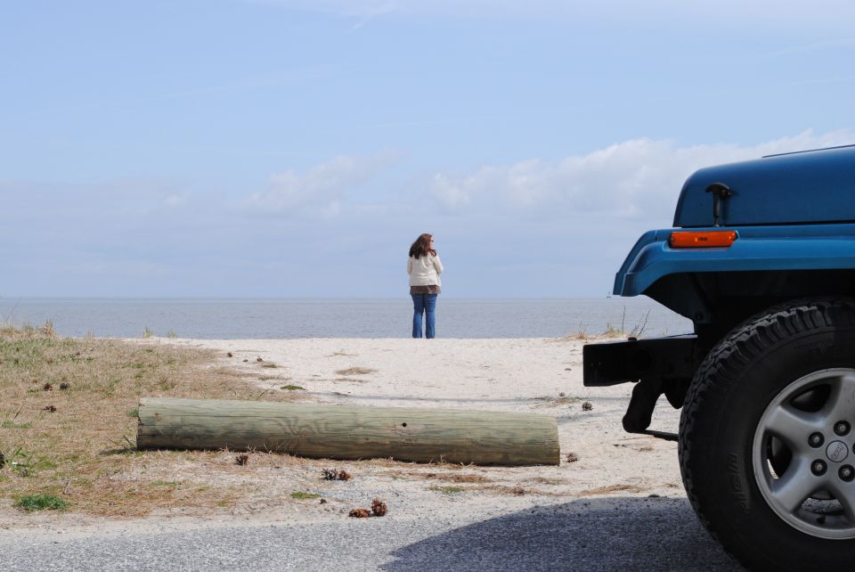 Blue Jeep YJ rear quarter panel and tire on a sandy beach