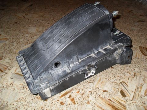 1990 Ford Bronco - Removed black plastic Ford air cleaner box with an embossed Ford oval logo, spring retaining clips, and threaded mounting studs with nuts,…