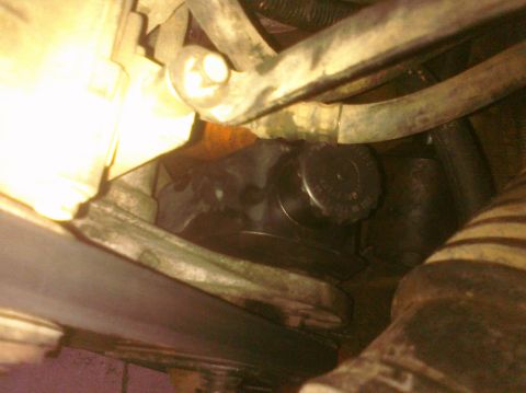 1995 Ford Bronco - A close-up view of a vehicle's power steering pump and associated hoses.