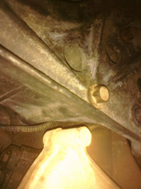 1995 Ford Bronco - Underside view of a vehicle's frame, focusing on a single bolt and surrounding metal components.