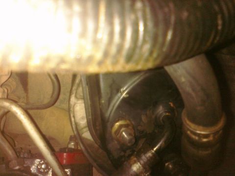 1995 Ford Bronco - Close-up of a power steering pump with attached hoses and metal lines, showing some wear and tear.