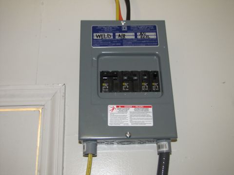 1993 Ford F-250 - A wall-mounted electrical breaker box with labels indicating circuits for welding, air, A/C, and reel.