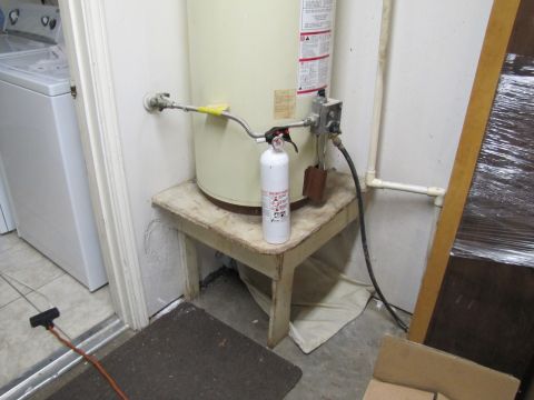 1993 Ford F-250 - A water heater is set up on a wooden stand with a fire extinguisher and plumbing connections.