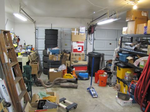 1993 Ford F-250 - A cluttered garage scene with various items including stacked tires, boxes, and exhaust pipes, suggesting a workshop or storage area.
