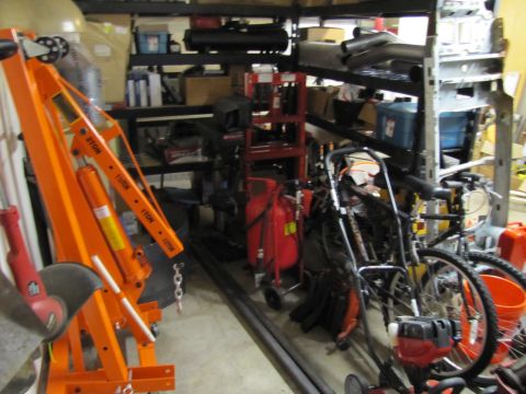 1993 Ford F-250 - Storage area filled with tools, equipment, and bicycles, including an orange engine hoist.