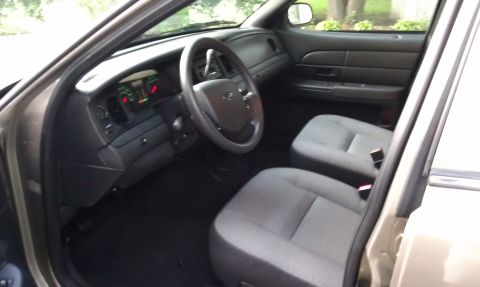 2007 Ford Crown Victoria - The interior of a 2007 Ford Crown Victoria is captured, highlighting the driver's side controls and seating arrangement.