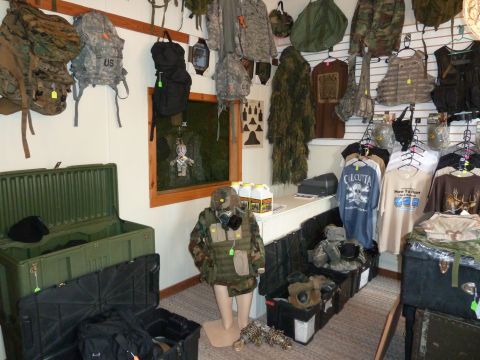1992 Ford Mustang - A store displays various military and outdoor equipment, including camouflage clothing and tactical gear.