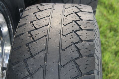 1996 Ford Bronco - A close-up view of a tire tread, with a chrome rim partially visible on the left side.