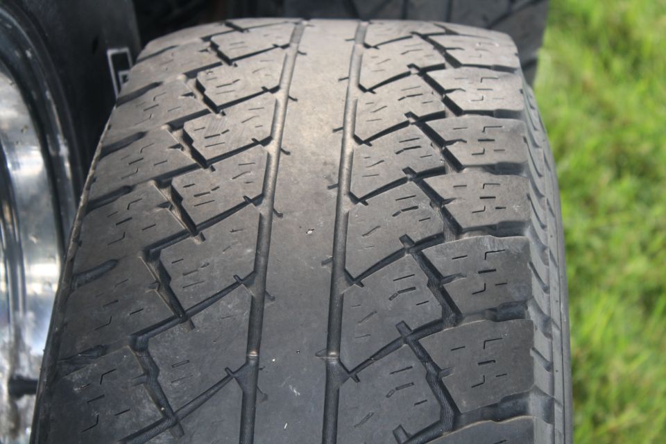 Close-up of a tire tread with a chrome rim visible on the left