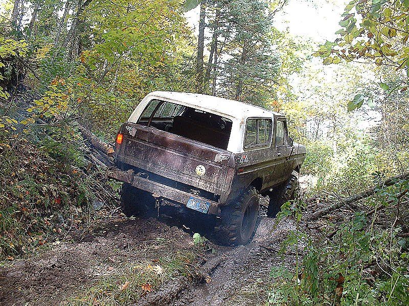 1978 Ford Bronco stuck in mud, rear 3/4 view