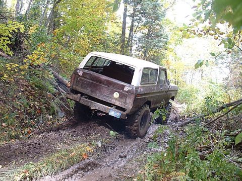 1978 Ford Bronco - This 1978 Ford Bronco is shown off-roading through a challenging muddy terrain in a forest.