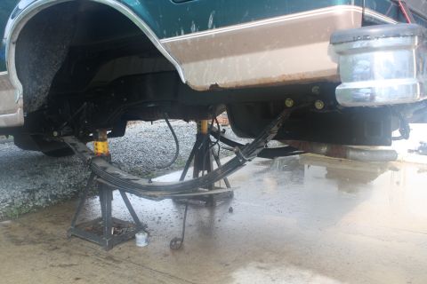 1996 Ford Bronco - The rear leaf spring suspension of a 1996 Ford Bronco is shown elevated on jack stands for service.