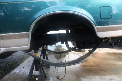 1996 Ford Bronco - Rear suspension of a 1996 Ford Bronco being worked on, supported by jack stands.