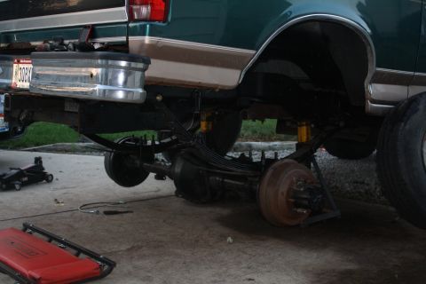 1996 Ford Bronco - The rear axle and suspension of a 1996 Ford Bronco are visible as it is being worked on.