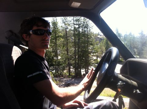 1990 Ford Bronco - A man drives a 1990 Ford Bronco through a wooded, mountainous area.