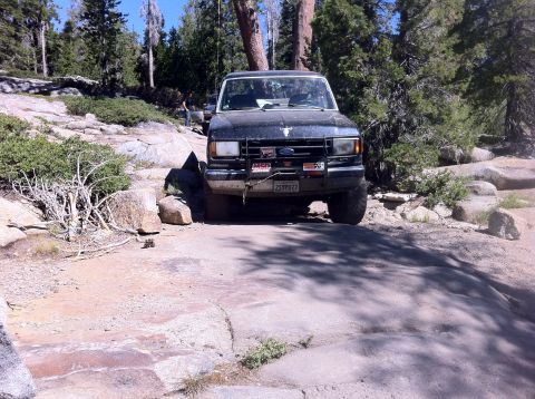 1990 Ford Bronco - Ford Bronco tackling a challenging rocky path during an off-road adventure.