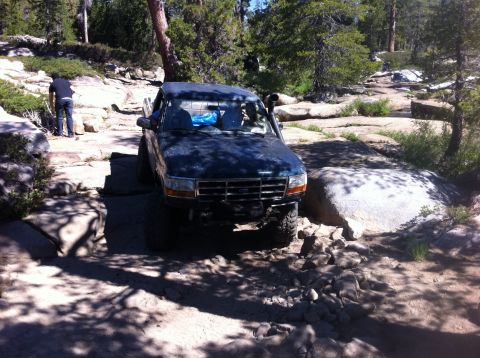 1990 Ford Bronco - This modified 1995 Ford F-150 navigates a challenging rocky trail in a wooded area.