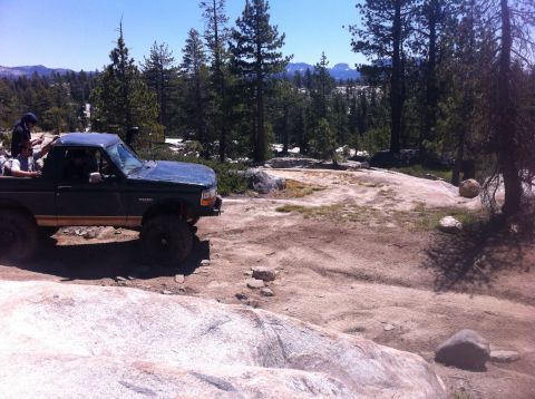1990 Ford Bronco - This 1990 Ford Bronco navigates a , rocky trail surrounded by pine trees.