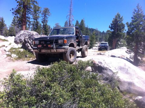 1990 Ford Bronco - Off-road adventure in a 1990 Ford Bronco on a sunny day, with a second vehicle visible.
