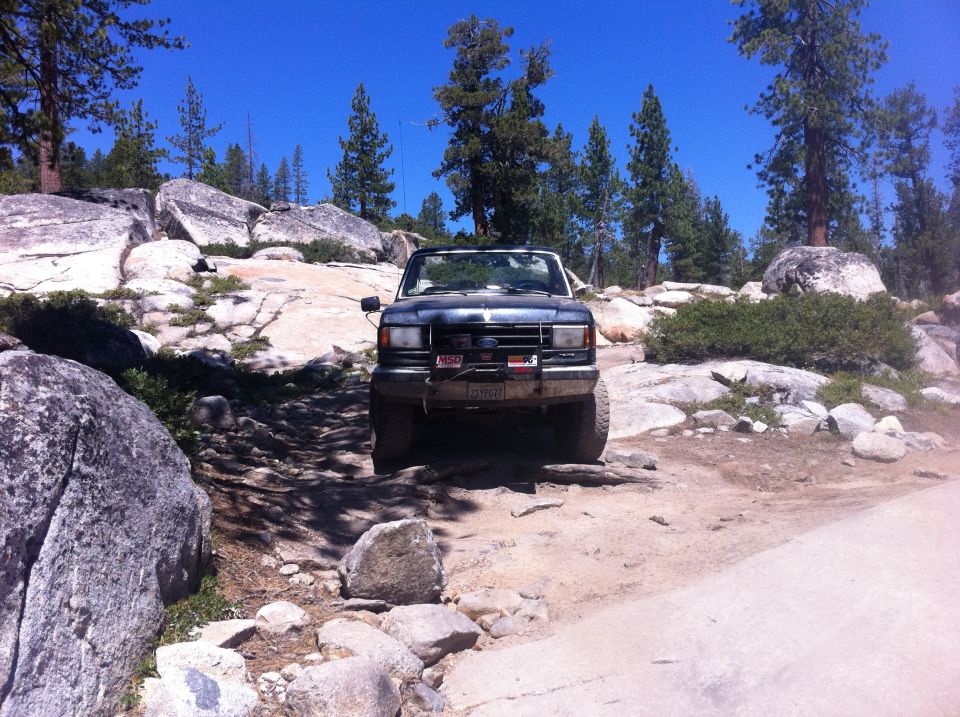 Ford Bronco on rocky trail, front view. Has a winch and off-road tires