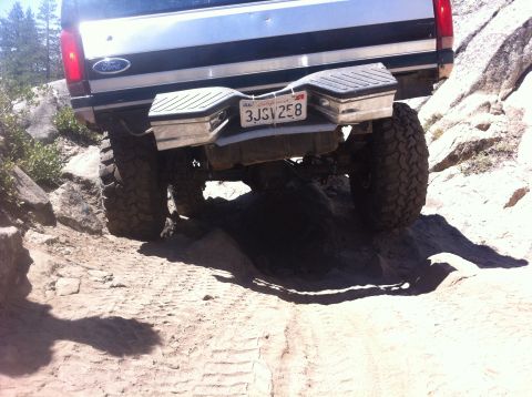 1990 Ford Bronco - Rear view of a 1990 Ford Bronco navigating a rocky off-road trail.