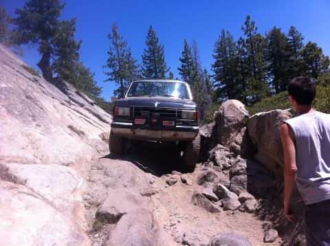 1990 Ford Bronco - 1990 Ford Bronco tackling a challenging rocky trail in the mountains.