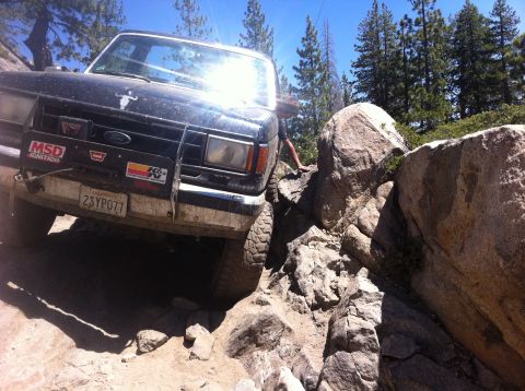 1990 Ford Bronco - This black Ford Bronco navigates a rocky trail, its front end angled towards the camera.