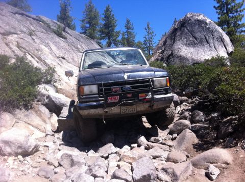 1990 Ford Bronco - This 1990 Ford Bronco tackles a challenging off-road trail with steep inclines and large rocks.