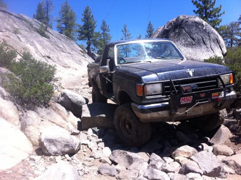1990 Ford Bronco - Ford F-Series truck tackles a challenging rocky trail, demonstrating its off-road capability.